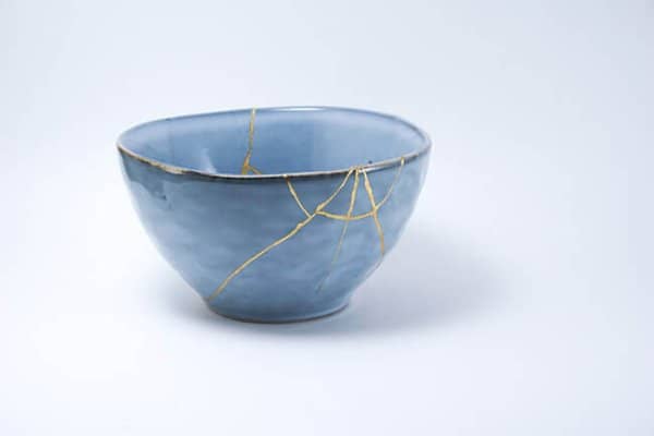 Blue kintsugi bowl. Gold cracks restoration on pottery restored